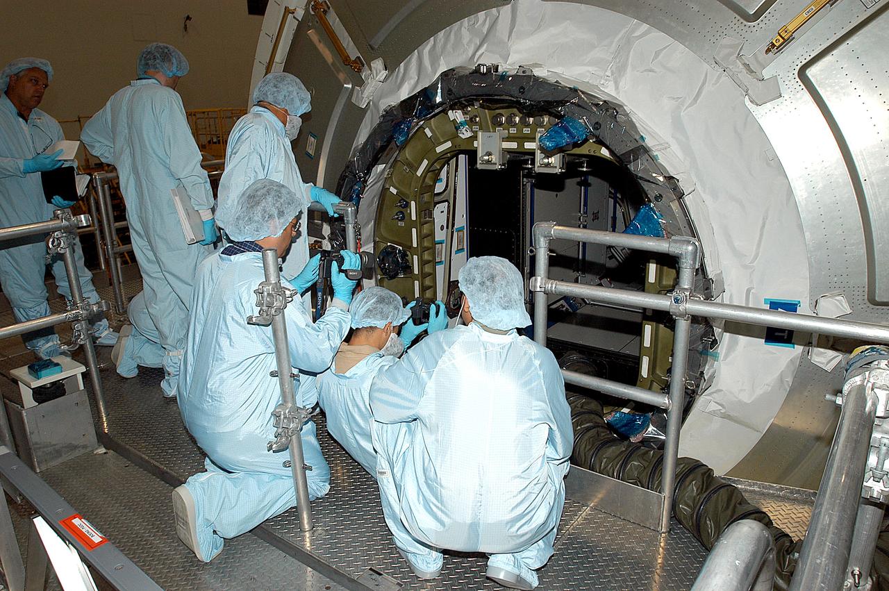 KENNEDY SPACE CENTER, FLA. - Workers in the Space Station Processing Facility attempt to open the hatch on the Italian-built Node 2, a future element of the International Space Station. Node 2 arrived at KSC June 1. The second of three Station connecting modules, the module attaches to the end of the U.S. Lab and provides attach locations for the Japanese laboratory, European laboratory, the Centrifuge Accommodation Module and, later, Multipurpose Logistics Modules. It will provide the primary docking location for the Shuttle when a pressurized mating adapter is attached to Node 2. Installation of the module will complete the U.S. Core of the ISS. Node 2 is the designated payload for mission STS-120. No orbiter or launch date has been determined yet.Installation of the module will complete the U.S. Core of the ISS. Node 2 is the designated payload for mission STS-120. No orbiter or launch date has been determined yet.